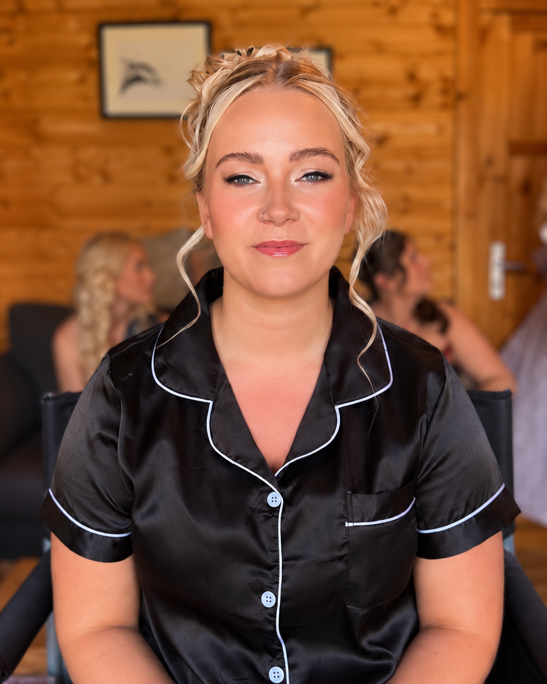 Soft bridal makeup with defined eyes and pink lips during wedding preparations in a wooden cabin