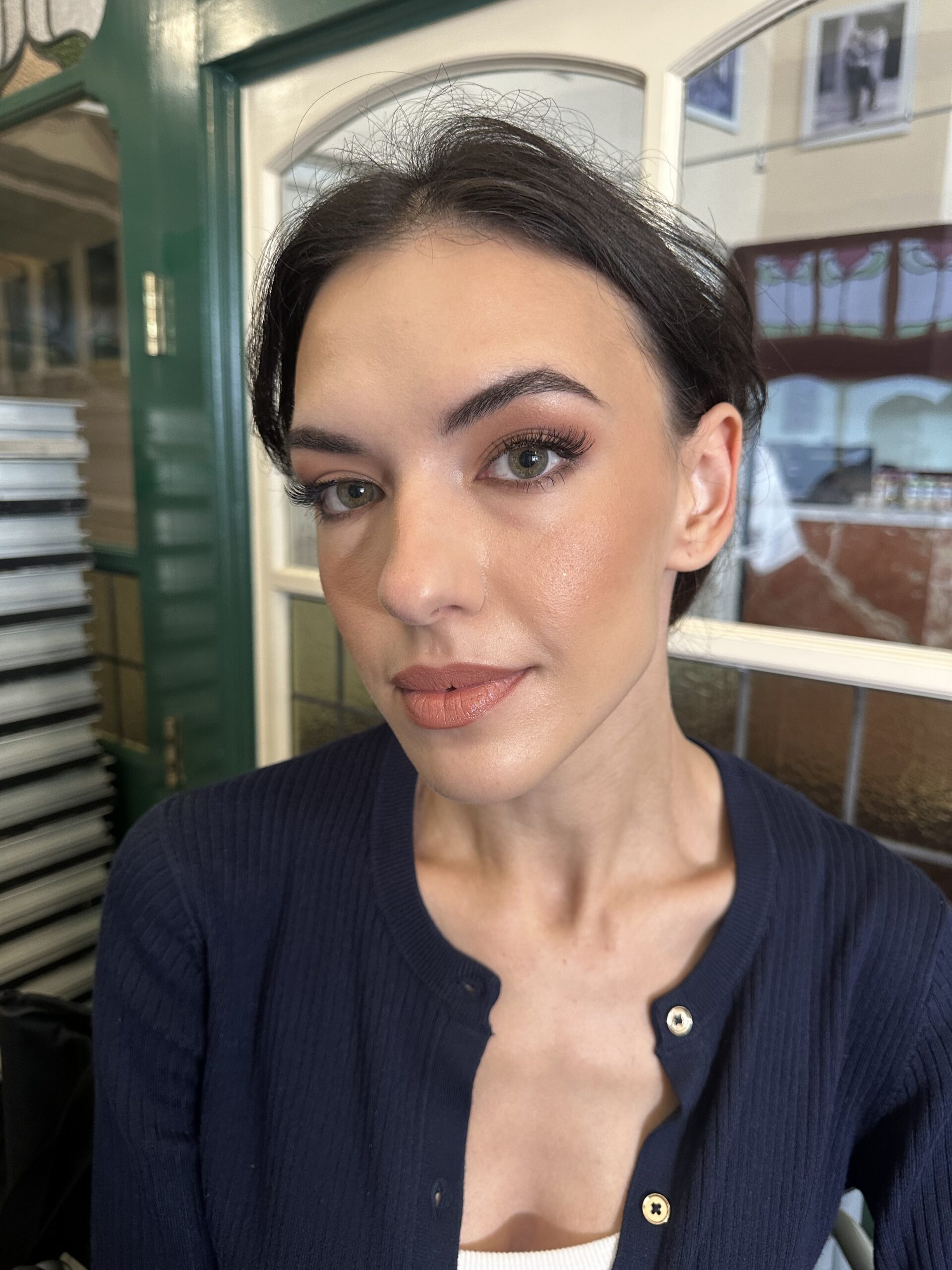 Soft bronze eye makeup and peach lips on a brunette model